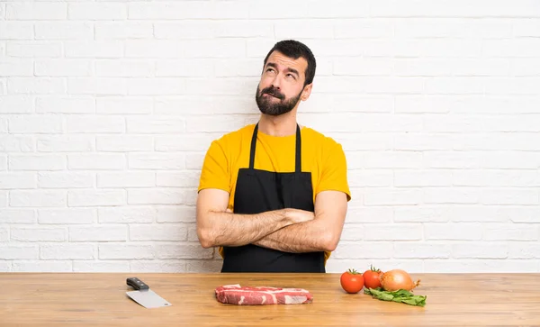 Chef holding in a cuisine with confuse face expression