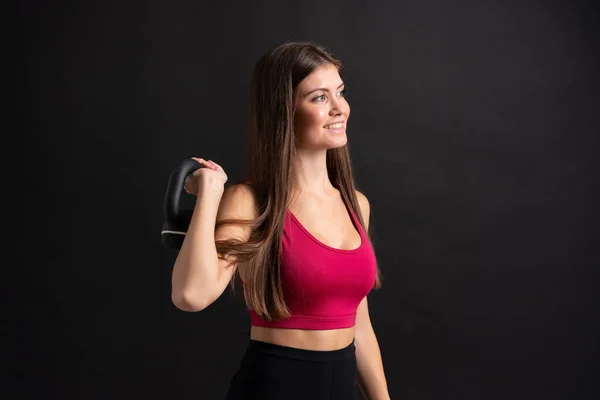 Young sport woman making weightlifting over isolated black background — Stock Photo, Image