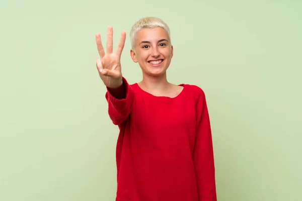 Yeşil Duvarda Beyaz Kısa Saçlı Genç Kız Mutlu Parmaklarıyla Üçe — Stok fotoğraf