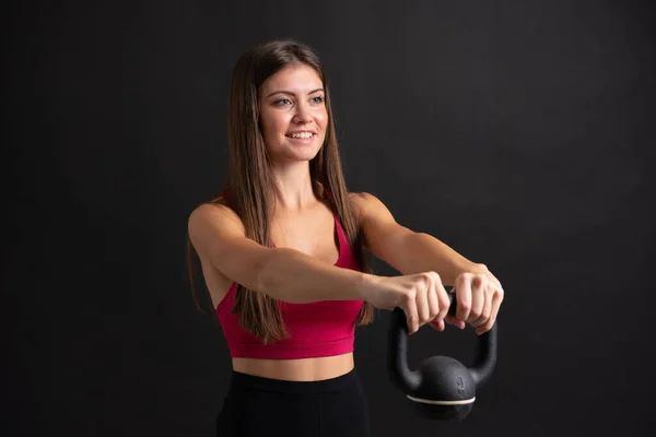 Jeune femme sportive faisant haltérophilie sur fond noir isolé — Photo