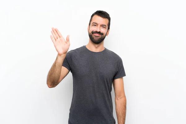 Junger Gutaussehender Mann Vor Isoliertem Weißen Hintergrund Salutiert Mit Fröhlichem — Stockfoto