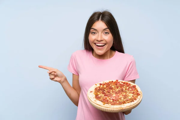 Bonita Jovencita Sosteniendo Una Pizza Sobre Una Pared Azul Aislada — Foto de Stock