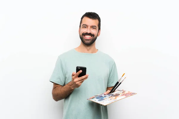 Arkaplanda Palet Tutan Genç Bir Sanatçı Cep Telefonuyla Bir Mesaj — Stok fotoğraf