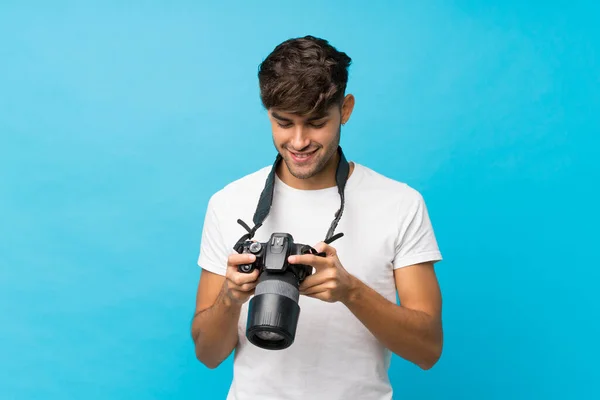 年轻英俊的男子 带着专业相机 背景深蓝色 与外界隔绝 — 图库照片