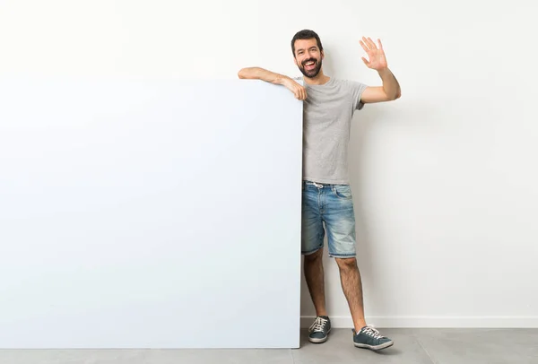 Jovem Homem Bonito Com Barba Segurando Grande Cartaz Azul Vazio — Fotografia de Stock