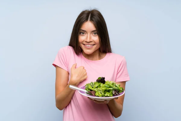 Jovem Com Salada Sobre Fundo Azul Isolado Com Expressão Facial — Fotografia de Stock