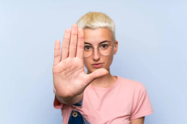 Menina Adolescente Com Macacão Parede Azul Fazendo Parar Gesto Com — Fotografia de Stock