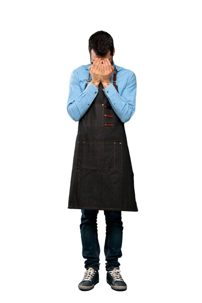 Full-length shot of Man with apron with tired and sick expression over isolated white background