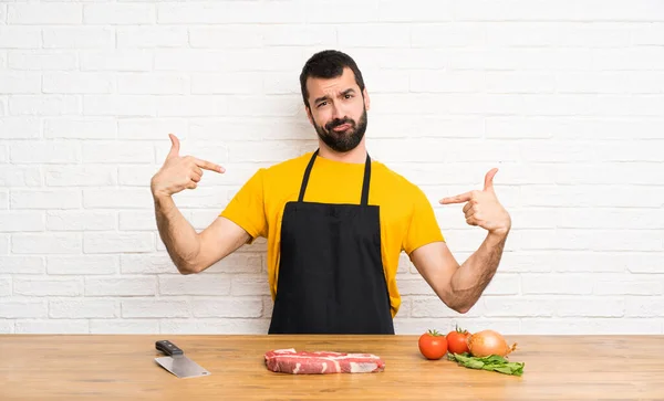 Chef holding in a cuisine proud and self-satisfied