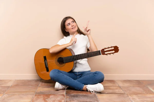 Jonge Vrouw Met Gitaar Zitten Vloer Wijzend Met Wijsvinger Een — Stockfoto