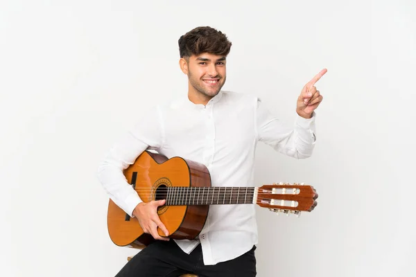 Jonge Knappe Man Met Gitaar Geïsoleerde Witte Achtergrond Verrast Wijzend — Stockfoto