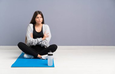 Genç spor kadın bir fikir düşünme mat ile katta oturan