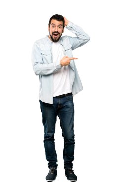 Yan tarafa izole beyaz arka plan için sakal şaşırmış ve işaret parmağınızla yakışıklı adamın tam uzunlukta atış