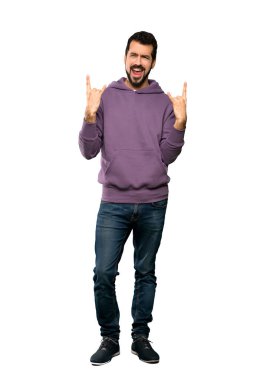 Eşofmanlı yakışıklı bir adamın izole edilmiş beyaz arka plan üzerinde taş jestleri yaptığı uzun bir çekim.