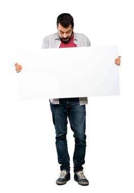 Boş bir afiş tutarak sakallı yakışıklı adam