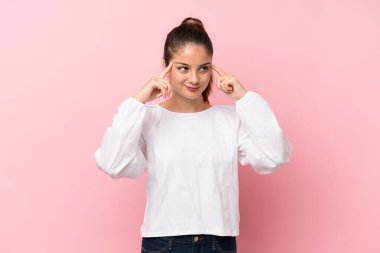 Tecrit edilmiş pembe arka planda genç esmer kız şüpheleri ve düşünceleri var.