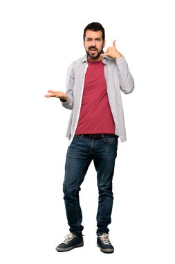 Full-length shot of Handsome man with beard making phone gesture and doubting over isolated white background