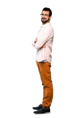 Uzun boylu, sakallı, kolları çaprazlanmış ve izole edilmiş beyaz bir arkaplanda ileriye bakan bir adam.