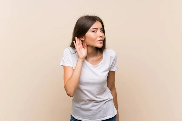 Ładna Młoda Dziewczyna Białym Tle Słuchając Czegoś Wkładając Rękę Ucho — Zdjęcie stockowe