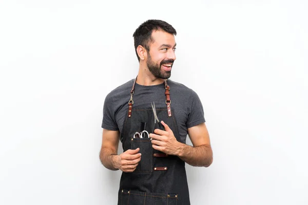 Barber man in an apron with arms crossed and happy