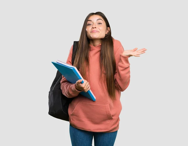 Joven Estudiante Sosteniendo Cuadernos Haciendo Gestos Dudas Sobre Fondo Gris —  Fotos de Stock