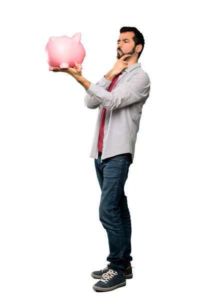 Handsome man with beard  holding a piggybank — Stock Photo, Image