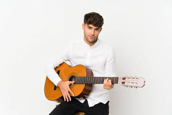 Jonge knappe man met gitaar over geïsoleerde witte achtergrond — Stockfoto