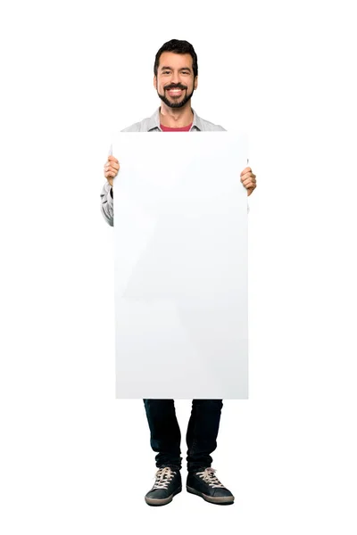 Homem bonito com barba segurando um cartaz vazio — Fotografia de Stock