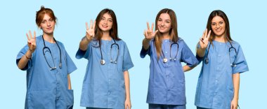 Bir grup hemşire mutlu ve parmaklarıyla üçe kadar sayıyor.