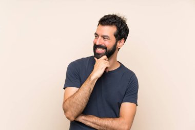 Sakallı ve yüzünde sürpriz ifade olan bir adam.