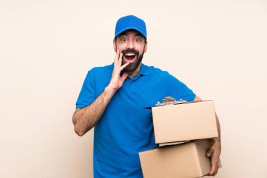 Arkaplanda sakallı bir teslimatçı. Şaşırmış ve şok olmuş bir yüz ifadesi var.