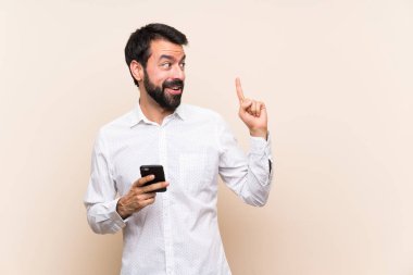 Elinde cep telefonu olan sakallı genç adam parmağını kaldırarak çözümü anlamaya çalışıyor.