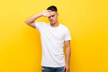 Yorgun ve hasta ifade ile izole sarı arka plan üzerinde Genç yakışıklı adam