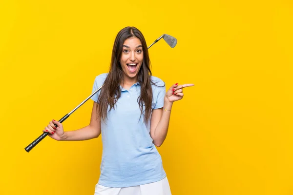 Young Golfer Woman Isolated Yellow Wall Surprised Pointing Finger Side — Stock Photo, Image