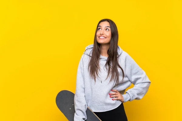 Wanita Skater Muda Dengan Latar Belakang Kuning Yang Terisolasi Melihat — Stok Foto