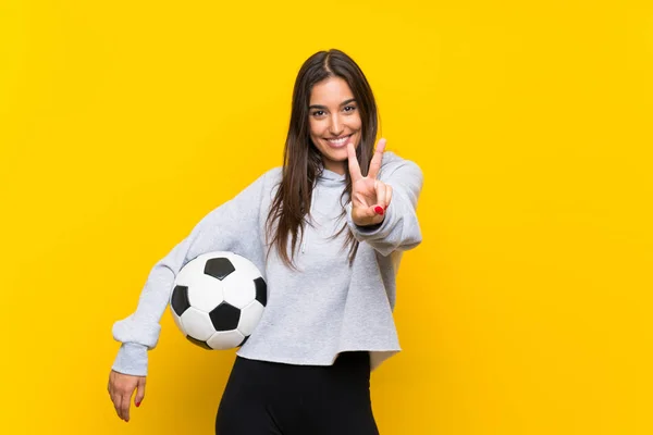 Młoda Piłkarz Kobieta Odizolowanym Żółtym Tle Uśmiechając Się Pokazując Znak — Zdjęcie stockowe