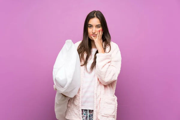 Young woman in pajamas and dressing gown over isolated purple background unhappy and frustrated