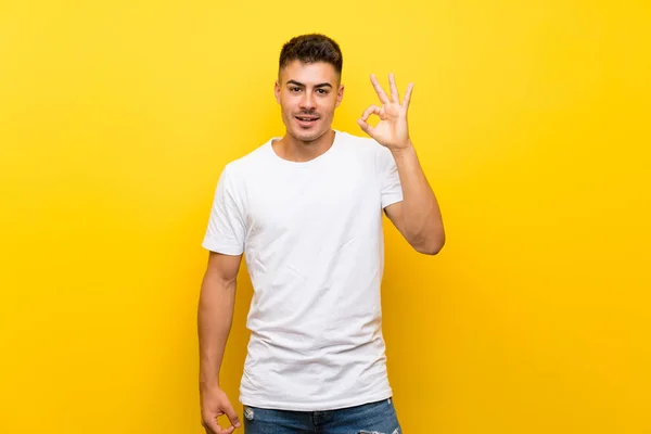 Mladý Pohledný Muž Přes Izolované Žluté Pozadí Překvapen Ukazuje Znamení — Stock fotografie