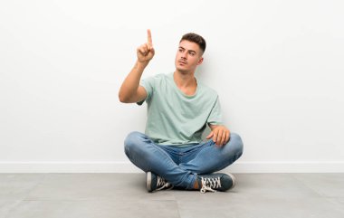 Şeffaf ekrana dokunarak katta oturan genç yakışıklı adam