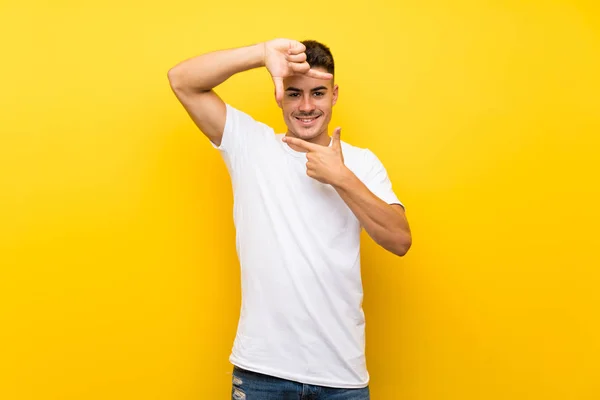 Joven Hombre Guapo Sobre Fondo Amarillo Aislado Enfocando Cara Símbolo —  Fotos de Stock