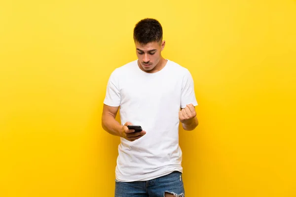 Joven Hombre Guapo Sobre Fondo Amarillo Aislado Sorprendido Enviando Mensaje —  Fotos de Stock