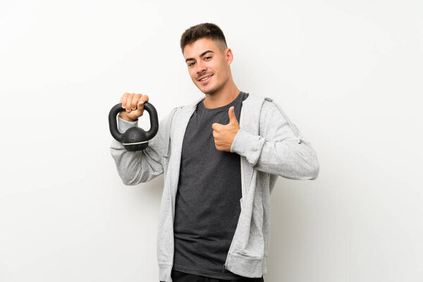 Спортсмен над белой стеной с поднятыми вверх большими пальцами, потому что произошло что-то хорошее
