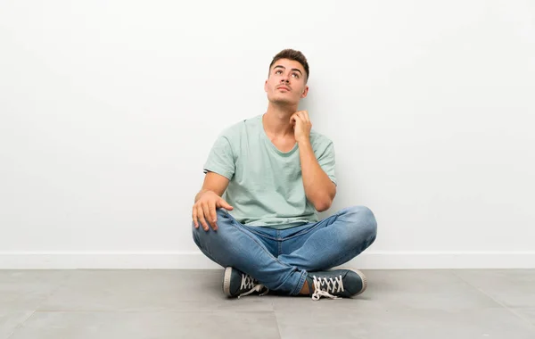 Mladý Pohledný Muž Sedící Podlaze Přemýšlející — Stock fotografie
