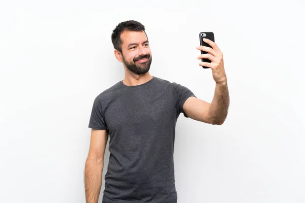 Soyutlanmış Beyaz Arka Planda Genç Yakışıklı Bir Adam Selfie Çekiyor — Stok fotoğraf