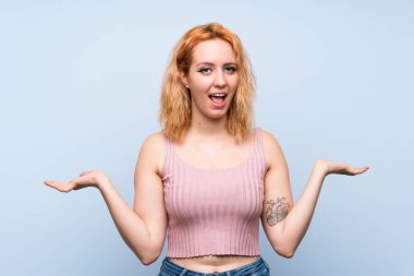 Yüzünde şok ifadesi olan, izole edilmiş mavi bir geçmişi olan genç kadın.