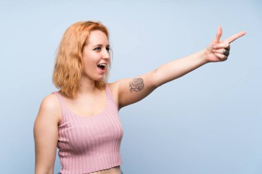 İzole edilmiş mavi arka planda genç bir kadın.