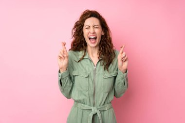 Genç, güzel bir kadın pembe arka planda, şans diliyor.