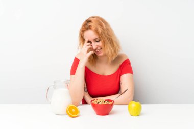 Genç kadın gülerek kahvaltı yapıyor