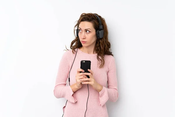 Mujer Bonita Joven Sobre Fondo Aislado Utilizando Móvil Con Auriculares — Foto de Stock