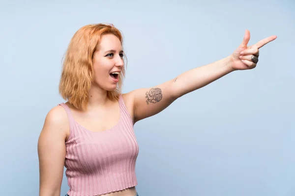 Jovem Mulher Sobre Isolado Fundo Azul Apontando Para Longe — Fotografia de Stock